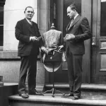 Philadelphia Police, exhibiting one of the twelve pint bottles of liquor hidden in the papier-mache clothes dummy, draped with an evening gown, found in the tailor shop they raided