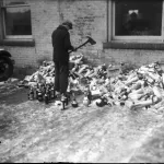 A man uses a firemen's axe to destroy alcohol confiscated during prohibitions raids throughout Detroit