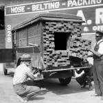 Alerted by the smell of a broken bottle of liquor, Federal Agents inspect a “lumber truck”. Los Angeles, 1926