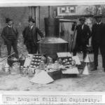 Lieutenant O.T. Davis, Sergeant J.D. McQuade, George Fowler of the IRS and H.G. Bauer posed with the largest bootlegging still confiscated until that date in 1922