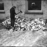 A man uses a firemen's axe to destroy alcohol confiscated during prohibitions raids throughout Detroit